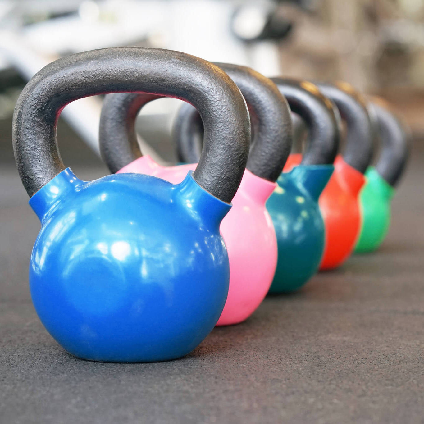 Colorful Kettlebells In A Row In A Gym