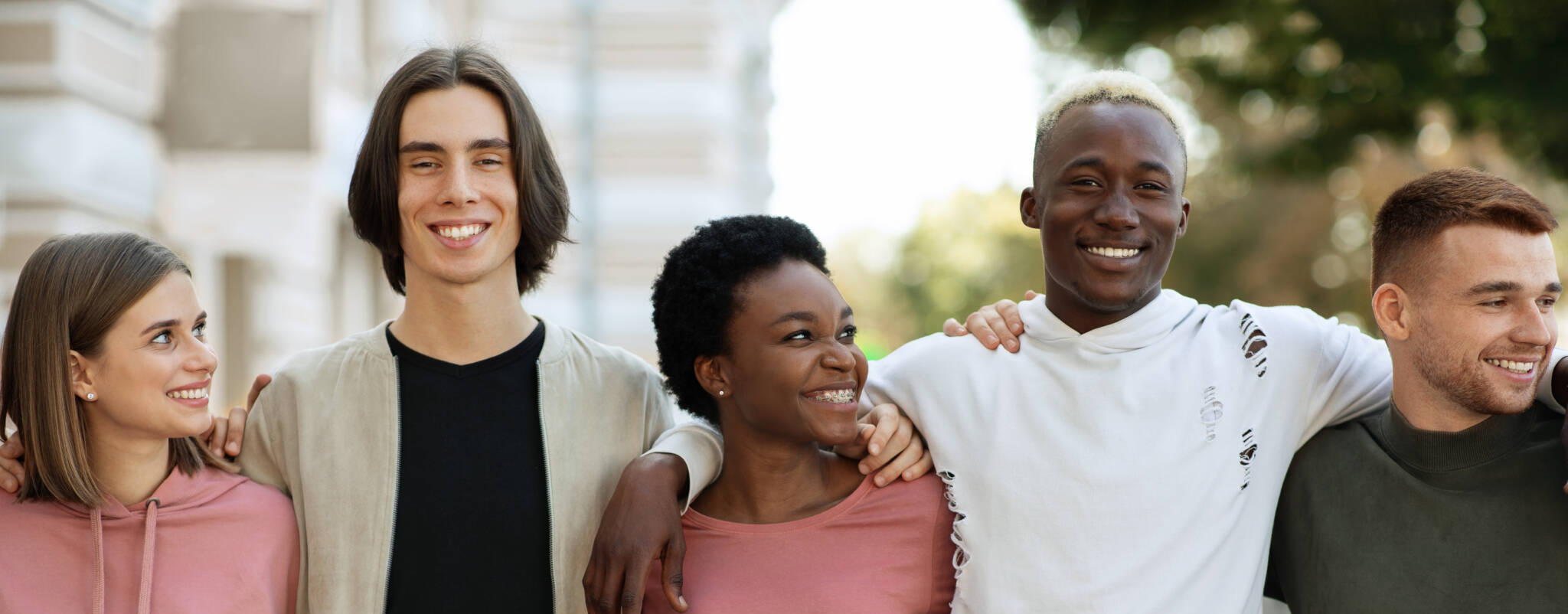 International Group Of Students Hugging While Standing On The Street